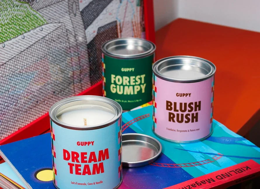 Trio de bougies parfumées Guppy sur des livres colorés